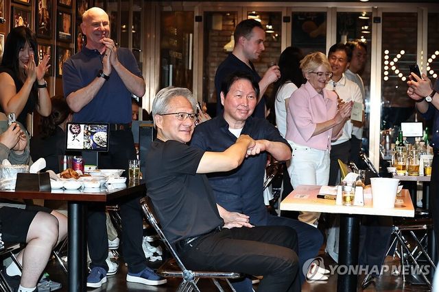 젠슨 황 엔비디아 최고경영자(CEO)와 최태원 SK 회장이 7일 서울 강남구 깐부치킨 삼성점에서 치맥 회동을 하던 중 주먹 인사를 하고 있다. 연합뉴스 제공