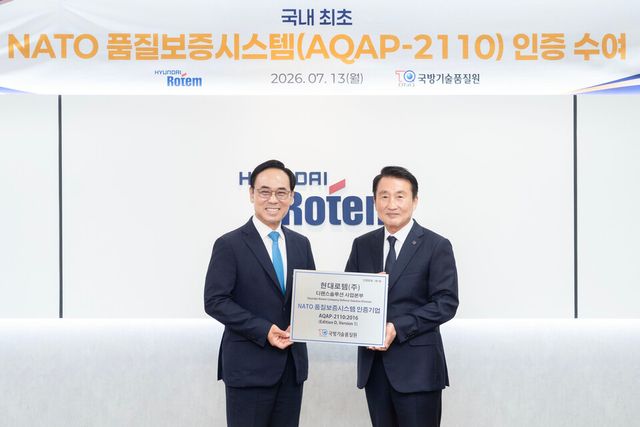 신상범 기품원장(오른쪽)과 이용배 현대로템 대표가 지난 13일 현대로템 의왕 본사에서 나토 품질보증시스템 인증 수여식을 마친 후 기념 촬영을 하고 있다./현대로템
