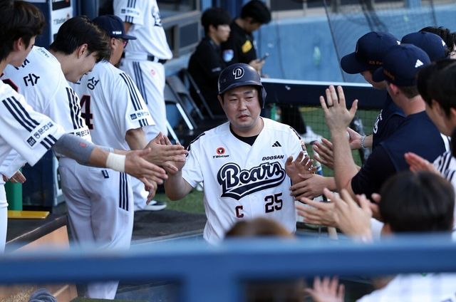 양의지(가운데)가 더그아웃에서 동료들의 축하를 받고 있다. /두산 베어스 제공