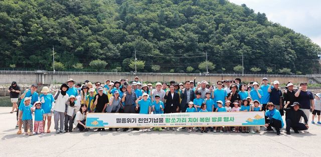 1일 강원도 화천군 화천읍에서 열린 황쏘가리 치어 방류 봉사활동에 참가한 에쓰오일 임직원과 가족들이 기념촬영을 하고 있다./ 에쓰오일