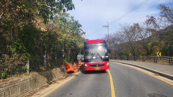 지난 7월부터 약 4개월간 방치돼 있던 매몰 토사로 낙석 방지 펜스가 내려 앉은 가운데 한 관광버스가 아슬하게 무너진 펜스 옆을 지나고 있다. 독자 제공