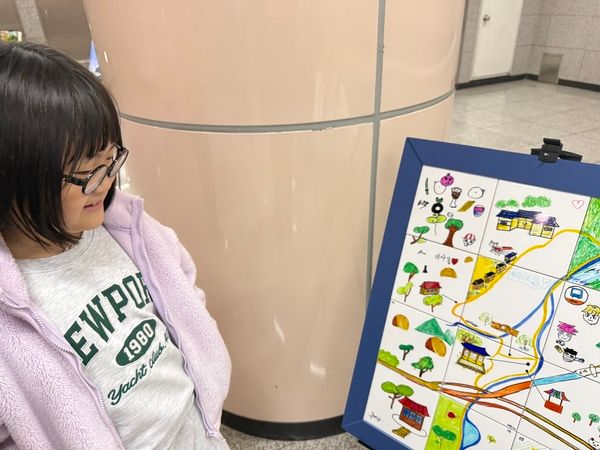 은혜지역아동센터 작품에 참가한 장채원 어린이가 자신이 그린 작품을 바라보고 있다. 이주빈 기자.