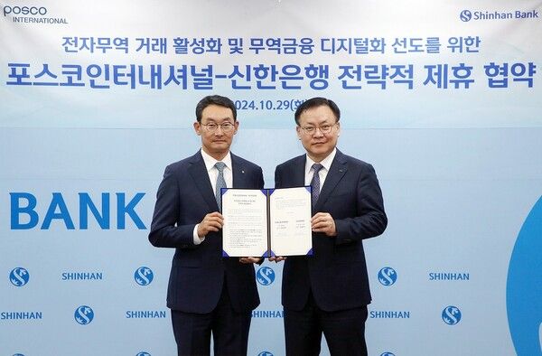 김광수 신한은행 고객솔루션 그룹장(왼쪽)과 정경진 포스코인터내셔널 경영기획본부장이 협약식 이후 서울시 중구 소재 신한은행 본점에서 진행된 ‘전자무역 거래 활성화 및 무역금융 디지털화 선도를 위한 전략적 업무협약식’에서 기념촬영을 하고 있다. [신한은행]