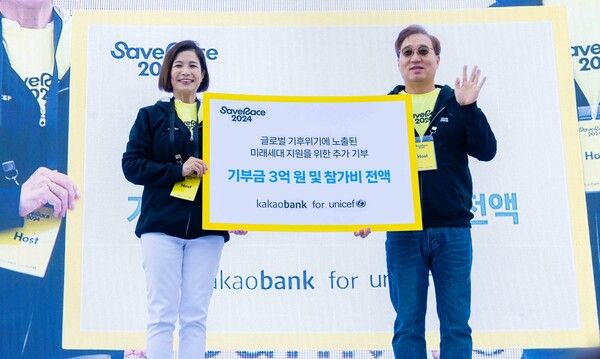 윤호영 카카오뱅크 대표이사(오른쪽)와 조미진 유니세프 한국위원회 사무총장(왼쪽)이 지난 10일 여의도 한강공원에서 열린 '2024 Save Race' 기부금 전달식에 참석해 기념 촬영을 하고 있다. [카카오뱅크]