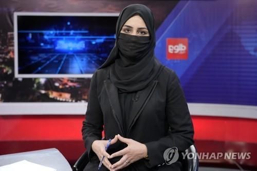 탈레반의 지시에 따라 마스크를 쓰고 진행에 나선 아프간 톨로뉴스 여성 앵커. [AP 연합뉴스]