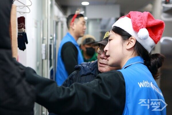 (왼쪽부터)이은미 토스뱅크 대표, 쪽방촌 주민, 정상훈 서울시 복지실장이 즉석에서 인화한 사진을 들고 기념사진을 촬영하고 있다 [토스뱅크]