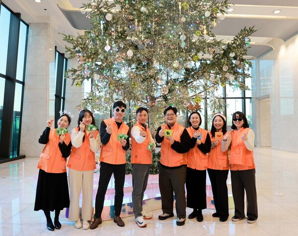 한화생명 임직원들로 구성된 한화생명 봉사단원들이 올해를 마무리하며 지난 23일 본사인 63빌딩 로비에 세워진 크리스마스 트리 앞에서, 내년도 적극적인 사회공헌 활동 참여를 다짐하는 기념촬영을 하고 있다. [한화생명]