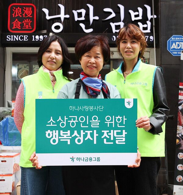 &nbsp;23일 하나금융그룹이 명동상인협의회와 함께 지역사회 소상공인을 위한 봉사활동을 실시했다고 밝혔다. (왼쪽부터) 강태은 명동상인협의회장과 지역 소상공인, 하나금융그룹 임직원이 기념촬영을 하고 있다. [하나금융그룹]