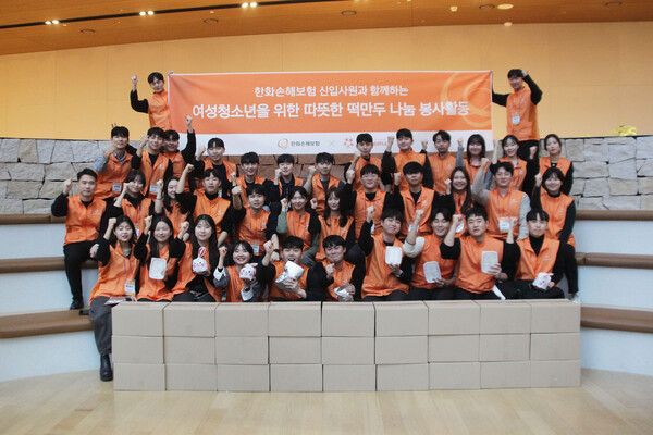 한화손해보험 신입사원들이 지난 13일 여의도 한화손보 본사 4층 타운홀에서 ‘떡만두 나눔’ 봉사활동을 진행하고 기념촬영을 하고 있다. [한화손해보험]