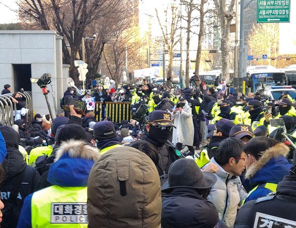 윤석열 대통령 구속영장 심사를 앞둔 18일 서울 마포구 서부지법 앞에서 경찰이 점거 농성 중인 윤 대통령 지지자들을 해산시키고 있다. [연합뉴스]