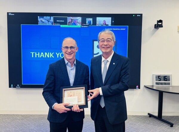 임종룡 우리금융그룹 회장이(오른쪽)과 스티븐 프레스턴 GII 대표이사가 지난 16일 미국 메릴랜드주 록빌에 위치한 굿윌스토어 본사에서 기념사진을 촬영했다. 이날 임 회장은 대한천일은행 설립인가서 액자를 프레스턴 대표이사에게 선물했다. [우리금융그룹]