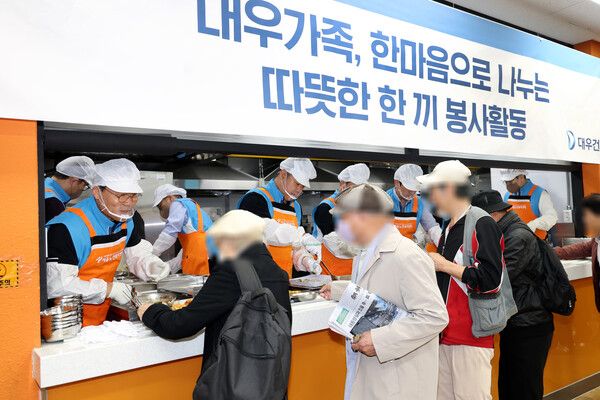 대우건설 김보현 대표이사(왼쪽)와 심상철 노동조합 위원장(오른쪽)이 무료 급식 봉사활동에 참여하고 있다. [대우건설]