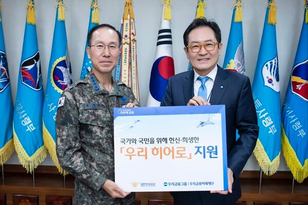 (왼쪽부터) 손석락 공군 참모총장과 장광익 우리금융미래재단 사무국장이 지난 28일 계룡대에서 공군에게 지원금을 전달하고 기념촬영을 했다. [우리금융]