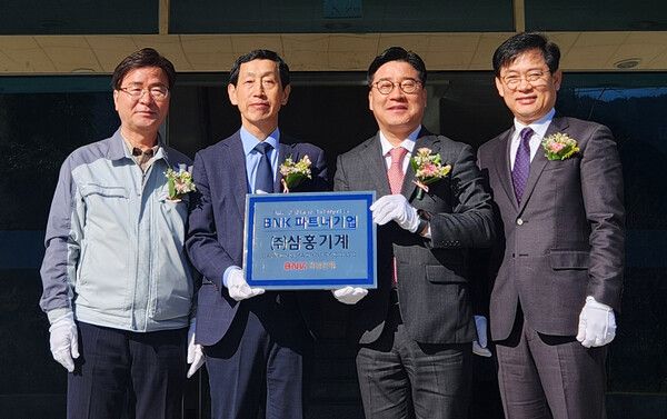 BNK경남은행 허종구 부행장(사진 오른쪽 두번째)과 삼홍기계 김홍범 대표 등이 파트너기업 현판 앞에서 기념촬영을 하고 있다. [BNK경남은행]