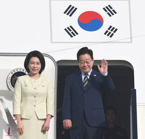 이집트 공식 방문을 마친 이재명 대통령과 김혜경 여사가 21일(현지시간) 남아공 주요 20개국(G20) 정상회의 참석을 위해 카이로 국제공항에서 공군 1호기에 올라 인사하고 있다. [연합뉴스]