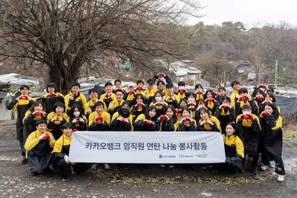 카카오뱅크 임직원들이 지난 25일 서울 강남구 구룡마을에서 ‘사랑의 연탄 나눔’ 봉사활동을 마친 뒤 기념촬영을 하고 있다. [카카오뱅크]