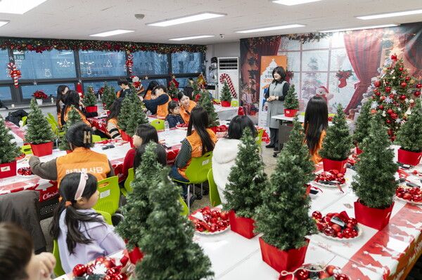 한화생명 임직원 봉사자들이 지난 17일 서울 영등포구 디모데 지역아동센터에서 ‘오렌지 산타’ 봉사활동으로 아동들과 함께 크리스마스 트리 장식을 하고 있다. [한화생명]