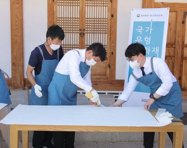 신협이 지원하는&nbsp;'전국 고택 관람환경개선 전통한지 지원 사업'에 참여한 김윤식 신협중앙회장(가운데)과 전주한지협동조합 관계자가 전통 제조방식으로 한지를 제작하고 있다. [신협]