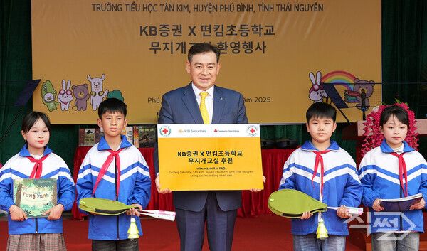 김성현 KB증권 대표이사가 지난 13일 베트남 타이응우엔성 푸빈현 떤킴초등학교에서 학생 대표에게 선물을 전달하며 기념촬영을 하고 있다. [KB증권]