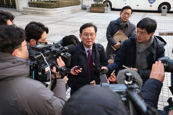 윤석열 대통령 변호인단인 윤갑근 변호사가 20일 서울 서초구 서울중앙지법에서 열린 윤석열 대통령 내란혐의 첫 형사재판에 출석하며 취재진의 질문에 답하고 있다. [연합뉴스]