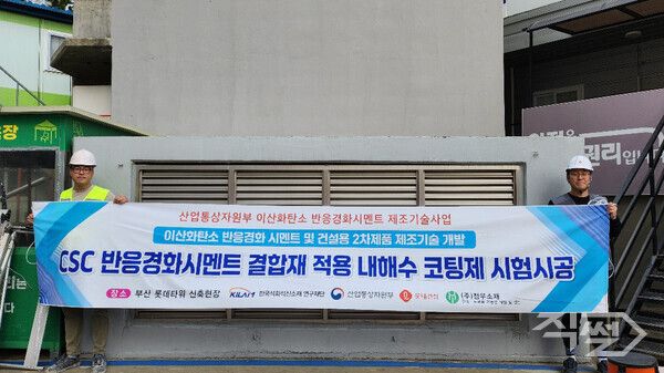 롯데건설 직원들이 부산 롯데타워 현장에서 이산화탄소 반응경화 시멘트를 활용한 코팅제를 시공하고 기념촬영을 하고 있다. [롯데건설]