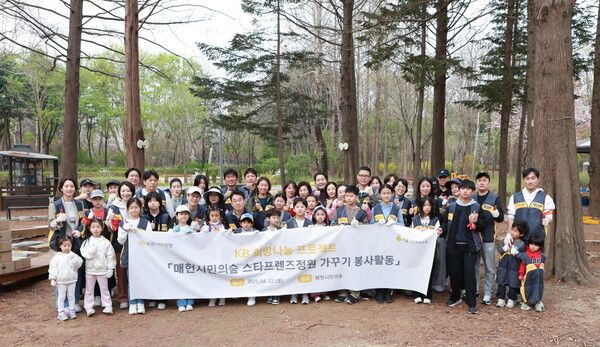 지난 12일 서울시 서초구 매헌시민의숲에 위치한 ‘KB국민은행 스타프렌즈정원’에서 진행한 봄 맞이 환경정비 봉사활동에서 KB국민은행 임직원 및 가족이 기념촬영을 하고 있다. [KB국민은행]