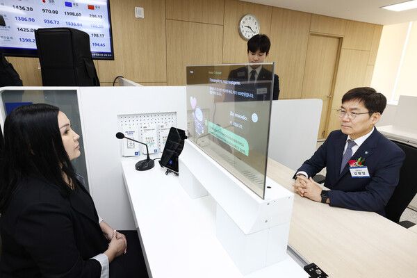 김형일 IBK기업은행 전무이사(오른쪽)가 13일 경기도 안산시에 위치한 기업은행 안산외국인금융센터에서 실시간 통번역서비스 시스템을 시연하고 있다. [IBK기업은행]