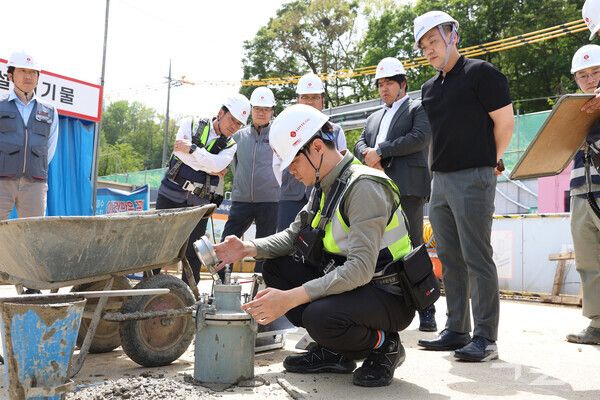 롯데건설 직원이 서초 헌인마을 현장에서 ‘차세대 혼화제’가 적용된 콘크리트를 테스트하고 있다. [롯데건설]