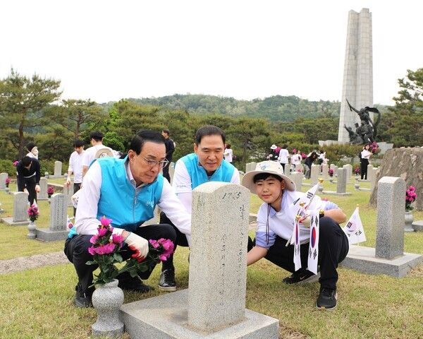 Sh수협은행(은행장 신학기)은 지난 19일, 서울 동작구 국립서울현충원에서 노동진 수협중앙회장을 비롯한 수협중앙회 임직원들과 함께 제70회 현충일 기념 묘역 돌봄활동을 실시했다. 행사에 참가한 노동진 수협중앙회장(왼쪽 첫 번째)과 신학기 Sh수협은행장, 임직원 자녀가 헌화와 태극기 꽂기 등 묘역 돌봄활동을 펼치고 있다. [Sh수협은행]