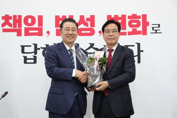 더불어민주당 김병기 당 대표 직무대행 겸 원내대표(왼쪽)가 17일 서울 여의도 국회에서 국민의힘 송언석 원내대표를 예방, 축하난을 전달하며 기념촬영하고 있다.