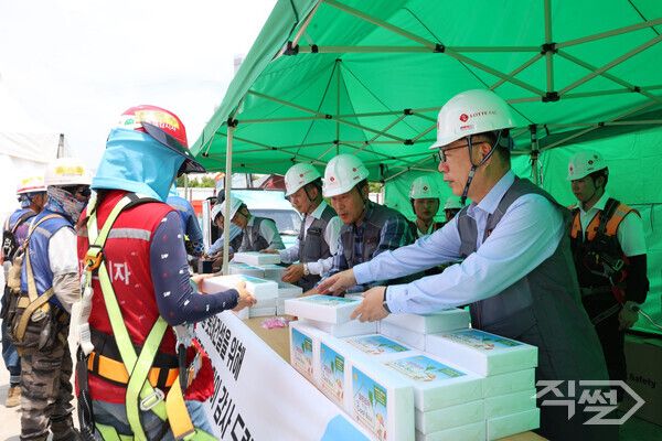 박현철 롯데건설 부회장(앞줄 오른쪽)이 지난 19일 대구 ‘타임빌라스 수성’ 현장에서 근로자들에게 아이스크림 츄러스와&nbsp;이온음료,&nbsp;혹서기 용품 등을 나눠주고 있다. [롯데건설]
