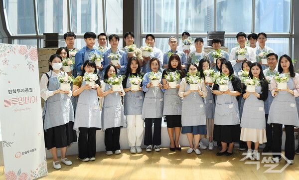 한두희 한화투자증권 한두희 대표이사(첫째줄 가운데)와 임직원들이 직접 만든 플라워 박스를 들고 기념촬영을 하고 있다. [한화투자증권]