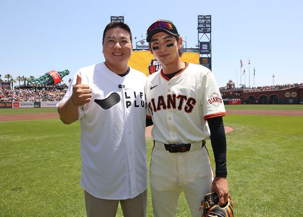 라이프플러스 '이정후 후디저지 데이(Jung Hoo Lee Hooded Jersey Day Presented by LIFEPLUS)'시구자로 나선 김태균 해설위원과 이정후 선수가 기념촬영을 하고 있다. [한화생명]