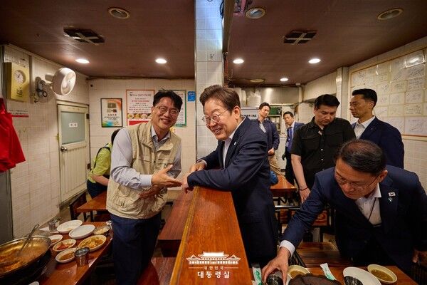이재명 대통령이 26일 점심 식사를 위해 방문한 서울 용산 대통령실 인근 한 식당에서 시민과 대화하고 있다. [대통령실]