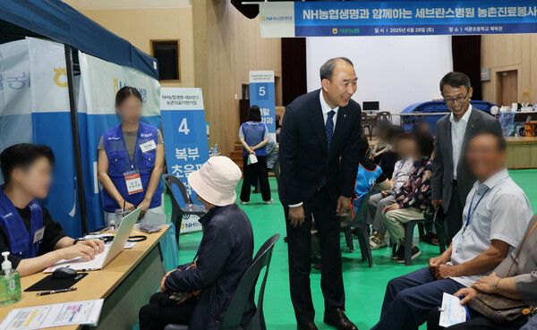 NH농협생명이 28일 충남 당진에서 올해 네 번째 농촌의료지원사업을 실시했다. 박병희 대표이사가 검진받는 조합원을 살피고 있다. [NH농협생명]