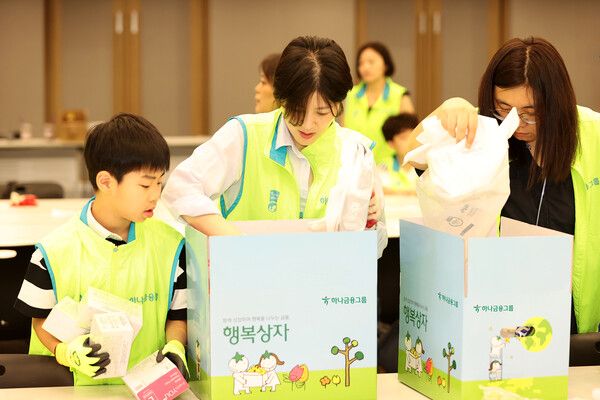 하나금융그룹은 지난 5일 명동상인협의회와 함께 지역 소상공인과의 상생을 위한 '행복상자 전달 및 행복한 줍깅' 임직원 봉사활동을 실시했다고 밝혔다. 이날 봉사활동에 참석한 하나금융그룹 임직원 및 가족들이 지역 소상공인들에게 전달할 행복상자를 정성껏 만들고 있다. [하나금융그룹]