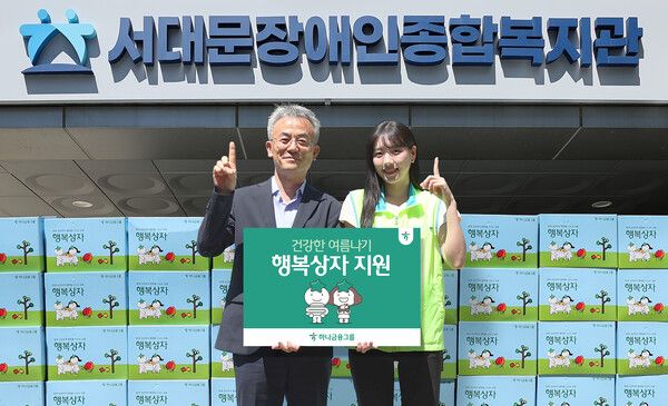 하나금융그룹은 연일 이어지는 폭염으로 어려움을 겪는 장애인 및 장애인 가족을 위해 폭염 대비 물품이 담긴 '건강한 여름나기 행복상자' 1111개를 전달했다. 이날 행사에 참석한 하나금융그룹 직원이 송용성 서대문장애인종합복지관장(사진 왼쪽)에게 행복상자를 전달하며 기념촬영을 하고 있다. [하나금융그룹]