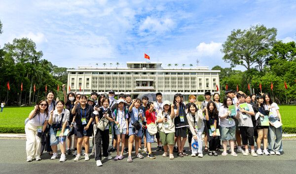 우미드림파인더 참가 아동청소년들이 호치민에 위치한 통일궁 앞에서 기념사진을 찍고 있다. [우미건설]