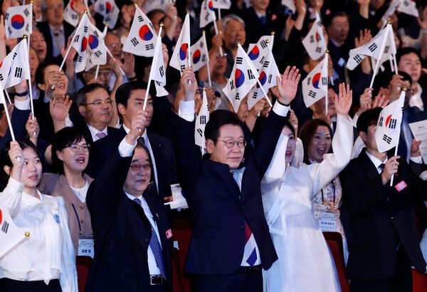 이재명 대통령과 김혜경 여사가 15일 서울 세종문화회관에서 열린 80주년 광복절 경축식에서 참석자들과 만세 삼창을 하고 있다.[이하 연합뉴스]
