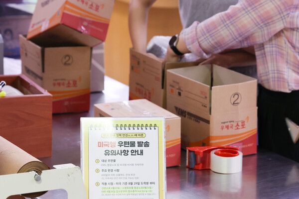 미국행 항공 소포 접수가 중단된 지난 25일 서울 종로구 광화문우체국에 미국의 관세 정책 변경에 따라 미국행 국제우편 접수 단계적 중단 관련 안내문이 놓여 있다. 이날부터 미국행 항공 소포, 26일부터 국제 특급 우편 서비스(EMS) 가운데 관세가 붙지 않는 서류를 제외한 모든 물품 등에 대한 우체국 창구 접수가 중지된다. 이 조치는 미국 정부의 관세 정책 변경이 적용되는 29일 0시(현지시간) 미국 도착분부터 적용되며, 서류 및 서신 등을 제외한 미국행 모든 국제 우편물은 신고 및 관세(15%) 부과 대상이 된다.[연합뉴스]