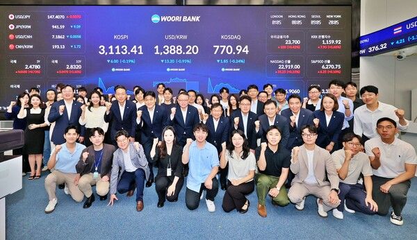 4일 우리은행 회현동 본점 자금시장그룹 딜링룸 전광판 점등식에서 정진완 은행장(두번째 줄 가운데)과 임직원들이 참석한 가운데 기념촬영을 하고 있다. [우리은행]