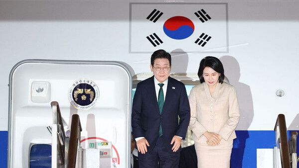 미국 방문 일정을 마치고 귀국한 이재명 대통령과 김혜경 여사가 26일 성남 서울공항에 착륙한 공군 1호기에서 인사하고 있다. [SBS 뉴스 화면 갈무리]