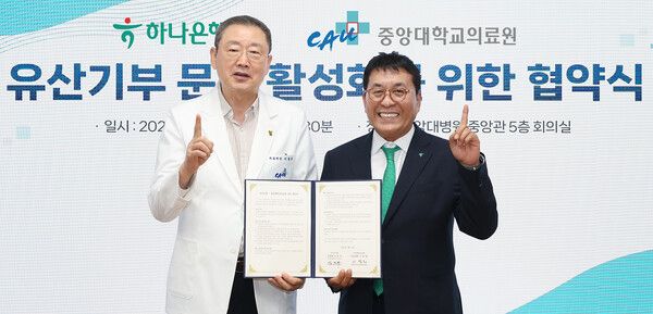 하나은행은 지난 4일 중앙대학교병원 중앙관 5층 회의실에서 중앙대학교의료원과 유산 기부 활성화를 위한 업무협약을 체결했다. 이날 협약식에 참석한 김진우 하나은행 중앙영업그룹 부행장(사진 오른쪽)이 이철희 중앙대학교의료원장(사진 왼쪽)과 협약서를 들고 기념촬영을 하고 있다. [하나은행]