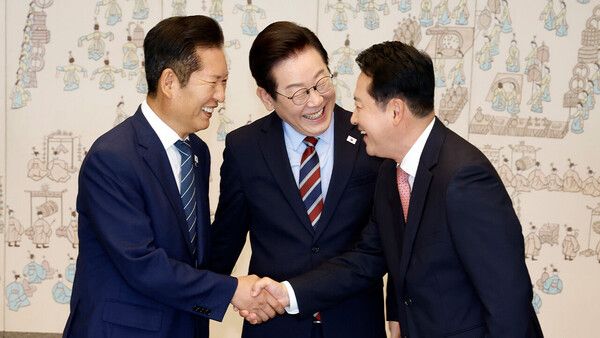 이재명 대통령이 8일 용산 대통령실에서 여야 지도부 오찬 회동에 참석한 더불어민주당 정청래 대표와 국민의힘 장동혁 대표가 악수하는 모습을 보고 있다. [연합뉴스]