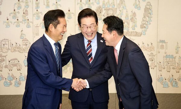 이재명 대통령이 8일 용산 대통령실에서 열린 여야 지도부 오찬 회동에 참석한 정청래(왼쪽) 더불어민주당 대표와 장동혁(오른쪽) 국민의힘 대표가 밝은 표정으로 악수하는 모습을 보며 함께 웃고 있다. 여야 대표가 손을 잡은 것은 지난달 26일 장 대표가 당선된 이후 처음이다. [연합뉴스]