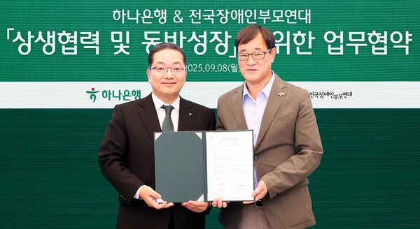 이호성 하나은행장(사진 왼쪽)이 윤종술 전국장애인부모연대 회장과 협약서를 들고 기념촬영을 하고 있다.[하나은행]