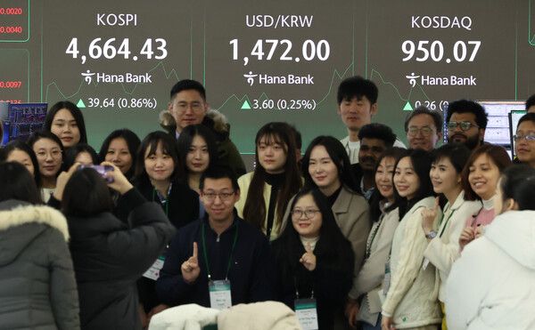 13일 오전 서울 중구 하나은행 딜링룸 현황판 앞에서 해외 현지 직원들이 기념촬영을 하고 있다. [연합뉴스]