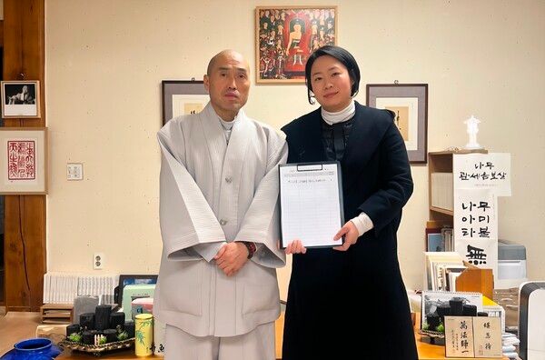 문나영 의원이 범어사 주지 스님으로부터 금정산 국립공원 본사무소 금정구 유치 서명을 받은 뒤 기념촬영을 하고 있다. [금정구의회]