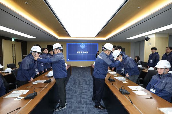 김보현 대표이사(왼쪽)와 심상철 노동조합 위원장(오른쪽)이 신입사원에게 안전모를 씌워주고 있다. [대우건설]