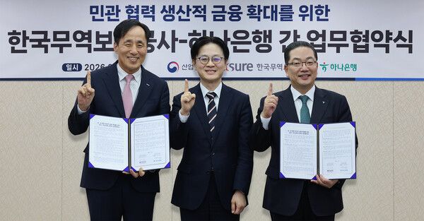 하나은행은 25일 오후 대한무역투자진흥공사(KOTRA) 본사에서 한국무역보험공사와 「민·관 협력 생산적 금융 확대를 위한 전략적 업무협약」을 체결했다. 이날 협약식에 참석한 이호성 하나은행장(사진 오른쪽)이 김정관 산업통상부 장관(사진 가운데), 장영진 한국무역보험공사 사장(사진 왼쪽)과 함께 협약서를 들고 기념 촬영을 하고 있다. [하나은행]